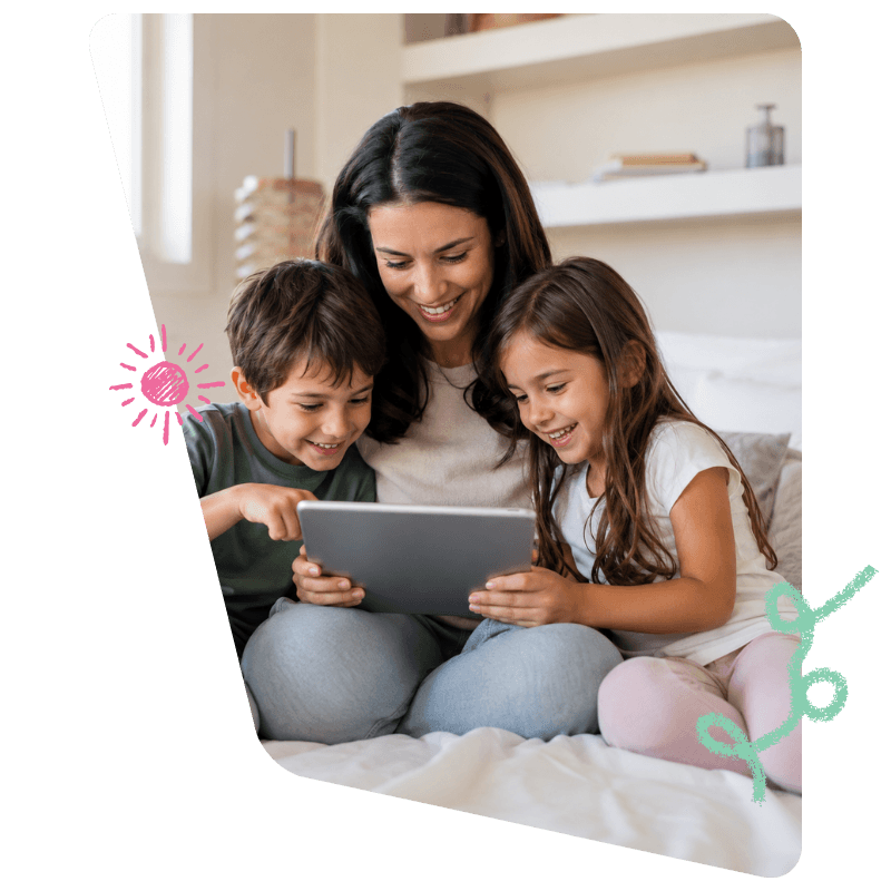 Una mamá con sus dos hijos jugando en una tablet, sentados en la cama